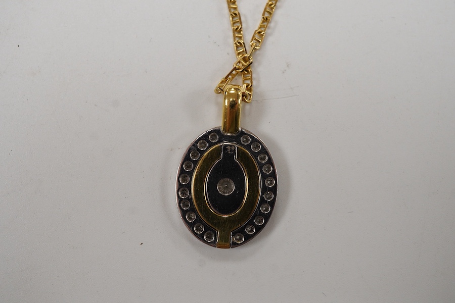 A yellow and white metal metamorphic oval pendant, with central diamond and diamond set border, closed 22mm, open 48mm, on an Italian 750 chain, 58cm, gross weight 16 grams.